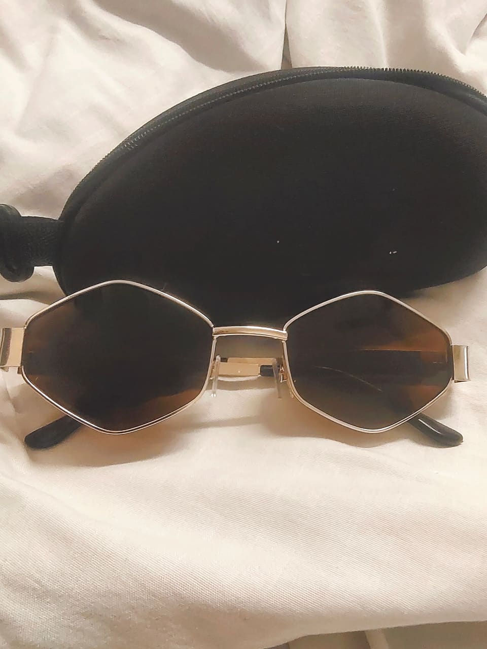 SK Style 02 hexagonal sunglasses resting on a black case