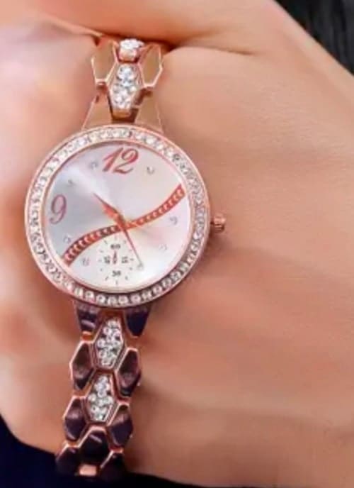 Close-up of a rose gold watch with a crystal bezel worn on the wrist